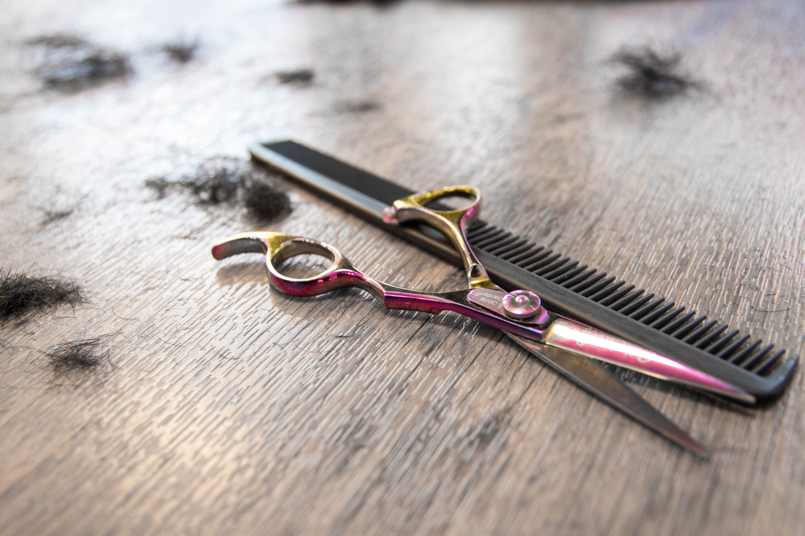 Friseurschere mit Rasiermesser auf einem Holztisch im Salon Baeumker